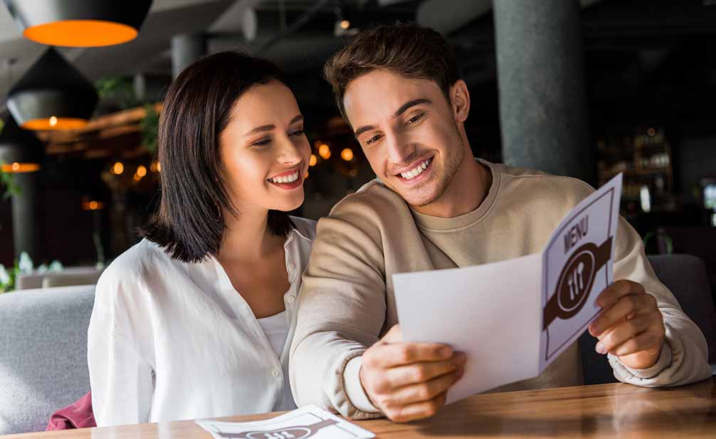 Pareja feliz con un tamaño de carta de menú equilibrado