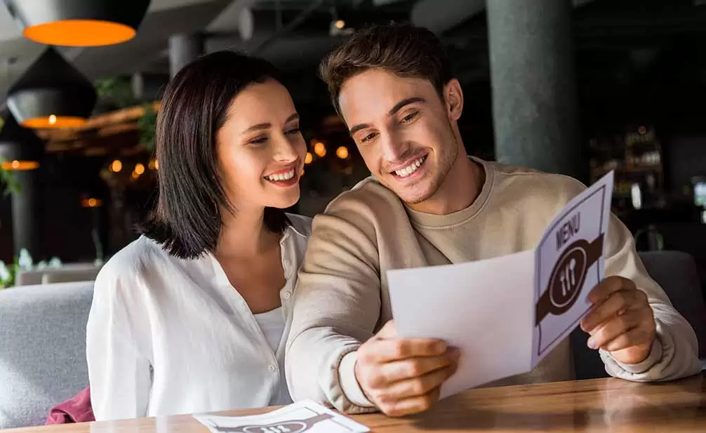 Pareja feliz con un tamaño de carta de menú equilibrado
