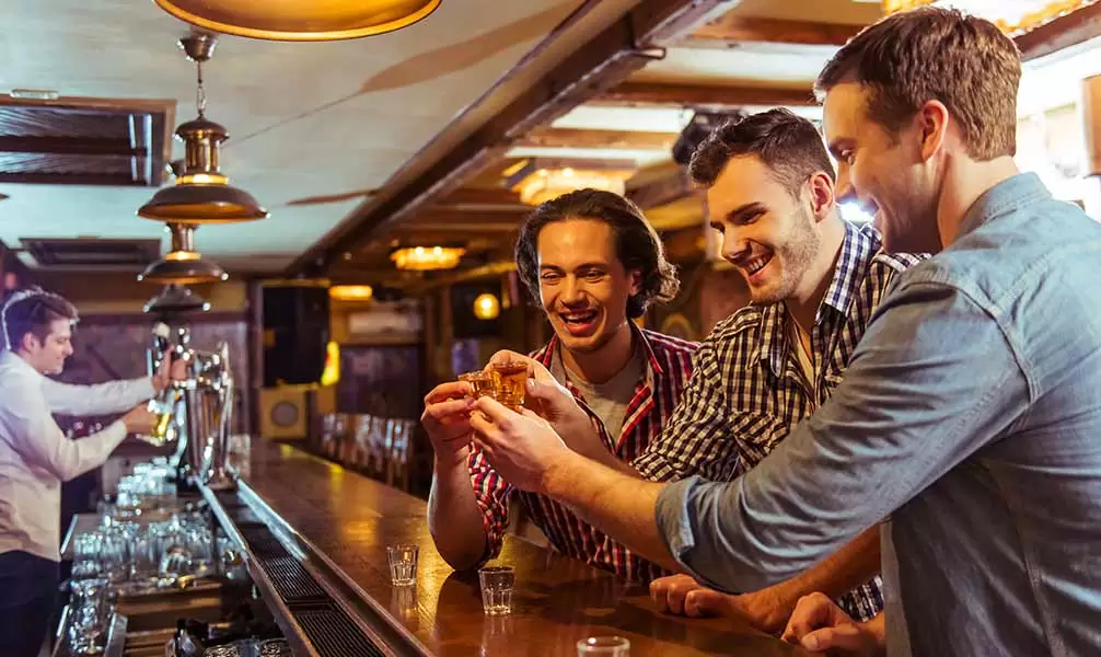 Clientes en un pub bebiendo chupitos y escuchando música