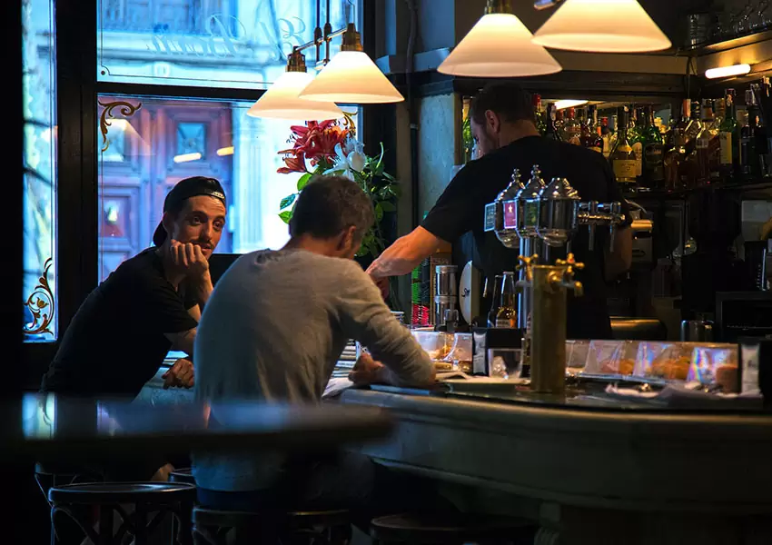 Hombres sentados en bar de tapas