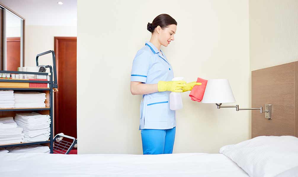 Personal de limpieza en tareas de limpieza de habitación de hotel