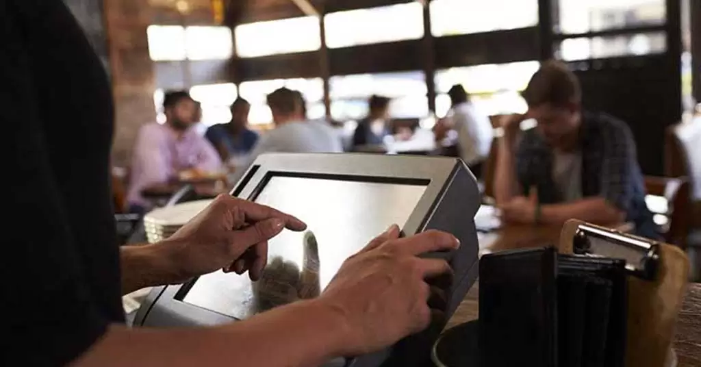 Camarero utilizando un TPV táctil para restaurantes